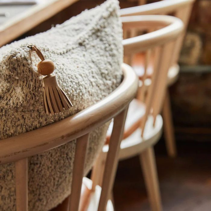 sustainable throw pillow on a wooden chair