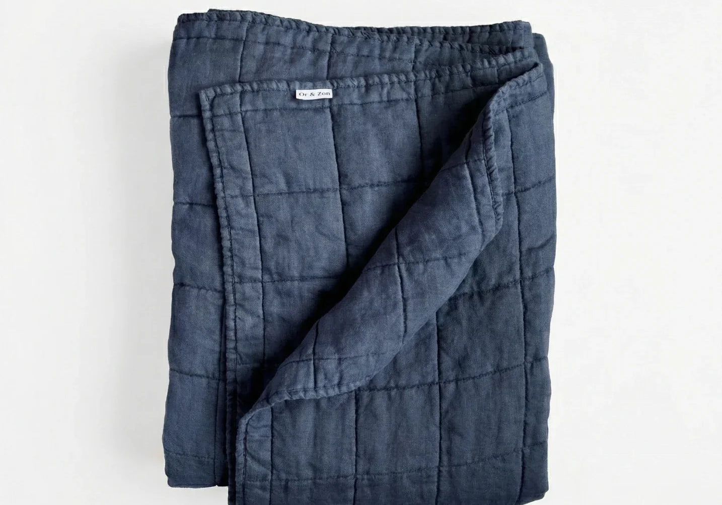 Best linen quilts 2026 — Or & Zon stonewashed French flax linen quilt in navy blue on a queen bed