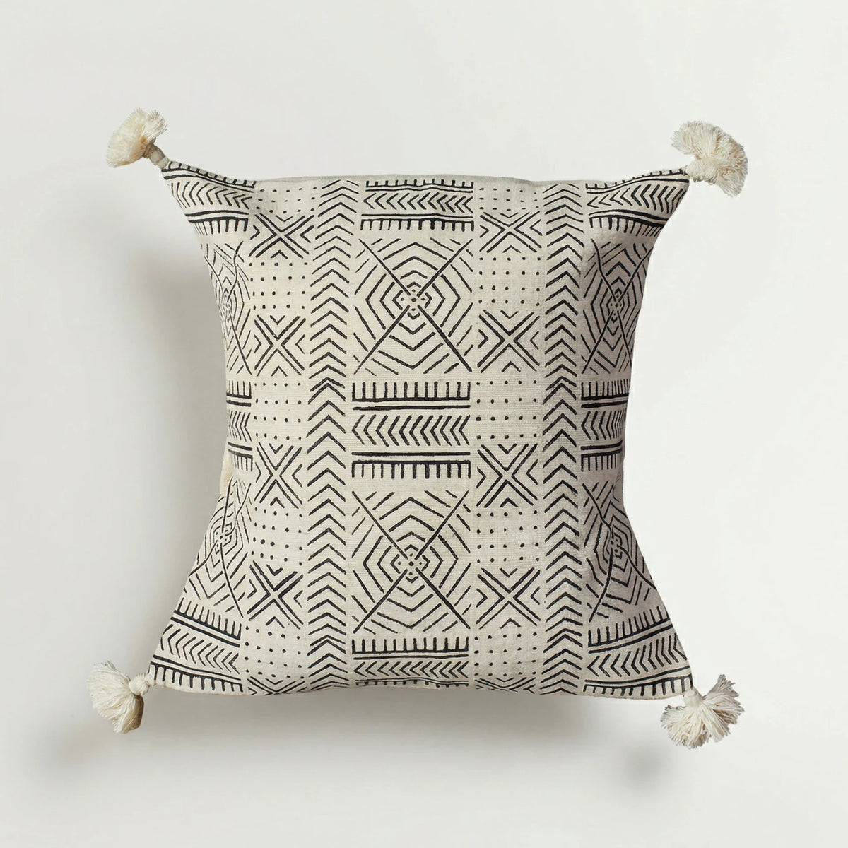 Decorative pillow with geometric pattern and tassels on a white background