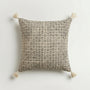 Decorative pillow with geometric pattern and tassels on a light background