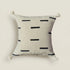 Decorative pillow with black line pattern on a beige background