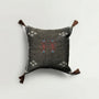 Decorative pillow with embroidered patterns on a light gray background