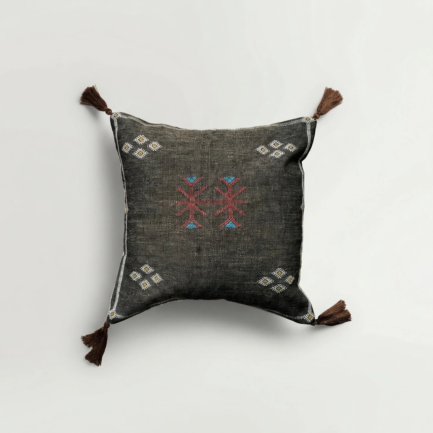 Decorative pillow with embroidered patterns on a light gray background