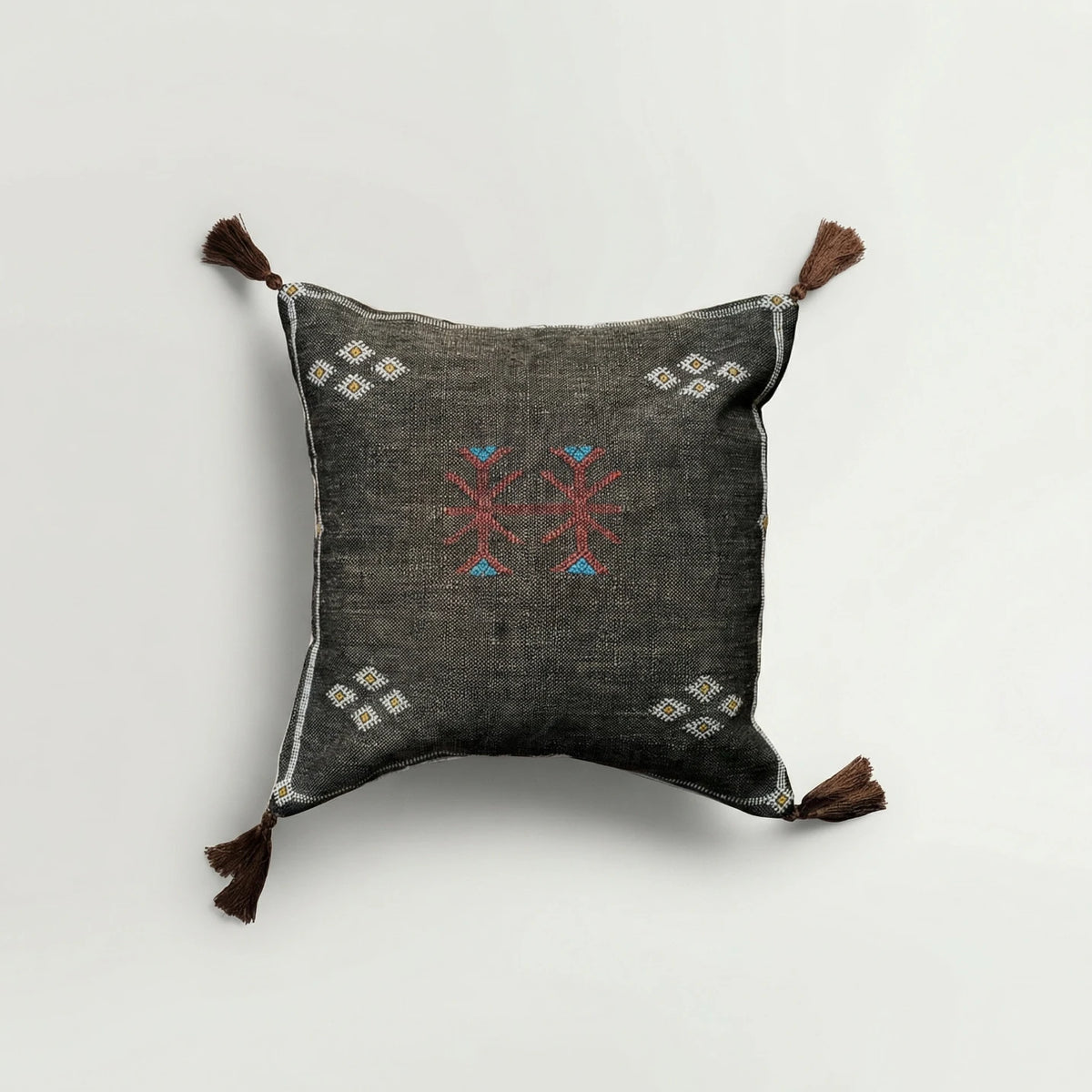 Decorative pillow with embroidered patterns on a light gray background