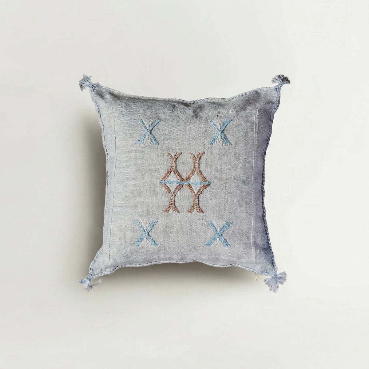 Decorative pillow with embroidered patterns on a light background