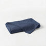 Folded blue denim fabric on a light gray background