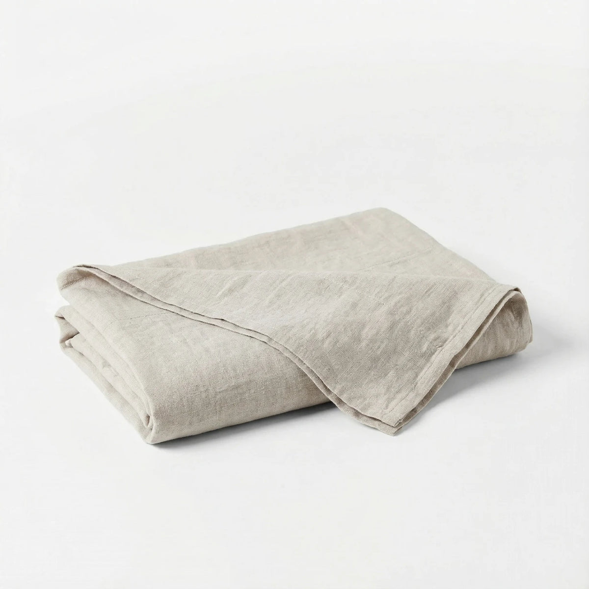 Folded beige blanket on a white background