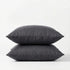 Two dark gray pillows stacked on a white background