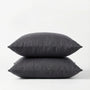 Two dark gray pillows stacked on a white background