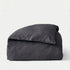 Folded dark gray comforter on a white background