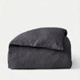 Folded dark gray comforter on a white background