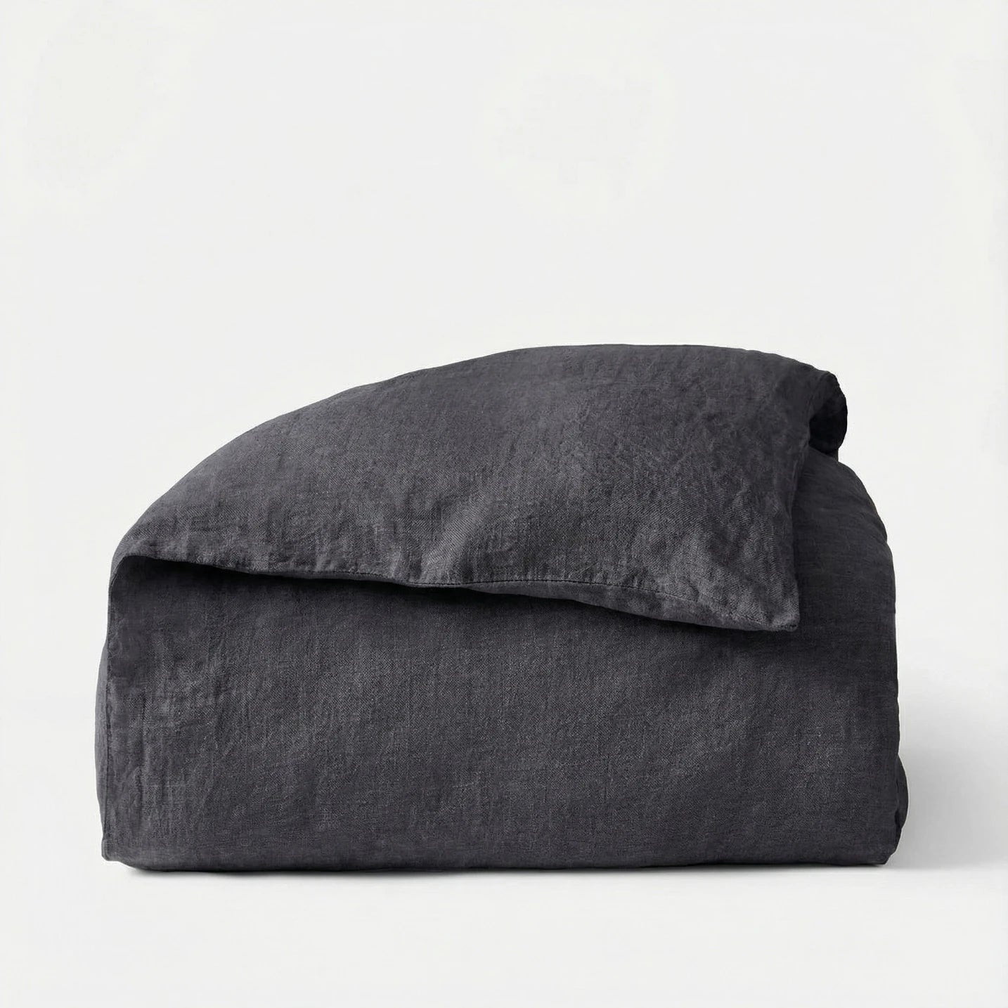 Folded dark gray comforter on a white background