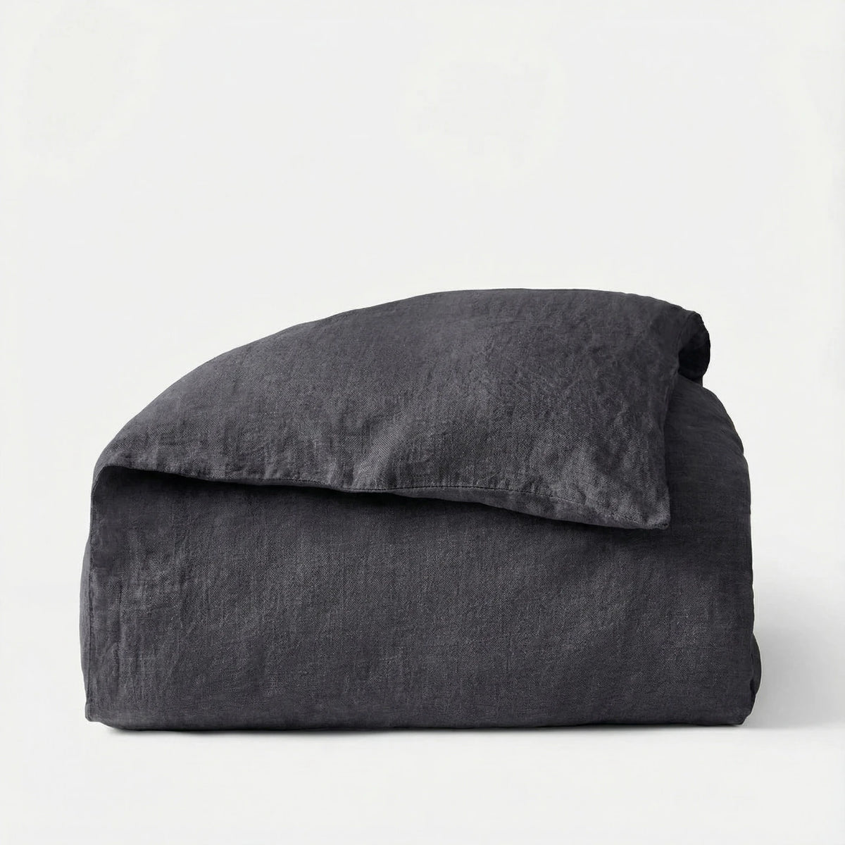 Folded dark gray comforter on a white background