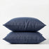 Two denim blue pillows stacked on a white background