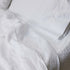 Alpine White sheet set styled on bed — GOTS-certified organic cotton sateen