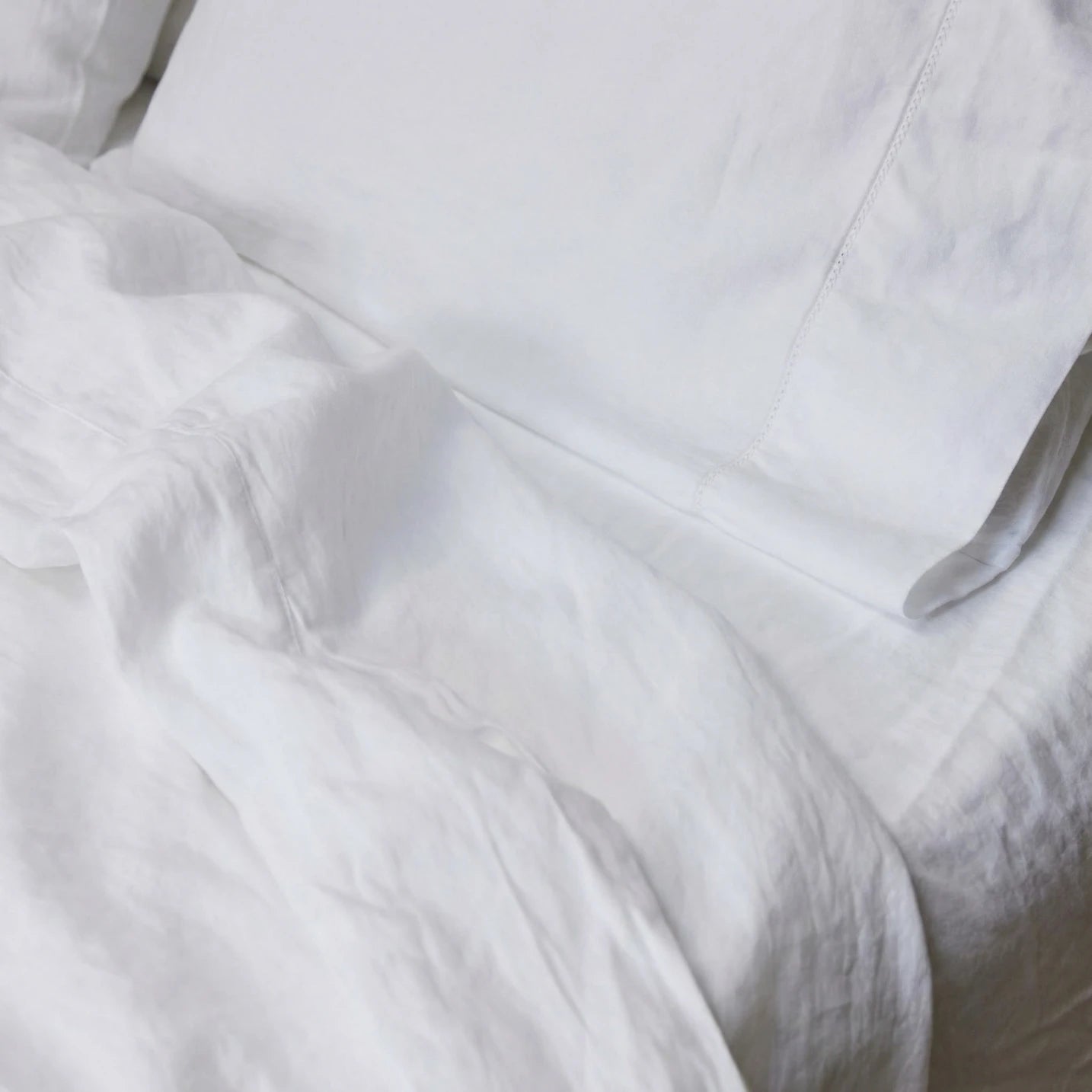 Alpine White sheet set styled on bed — GOTS-certified organic cotton sateen