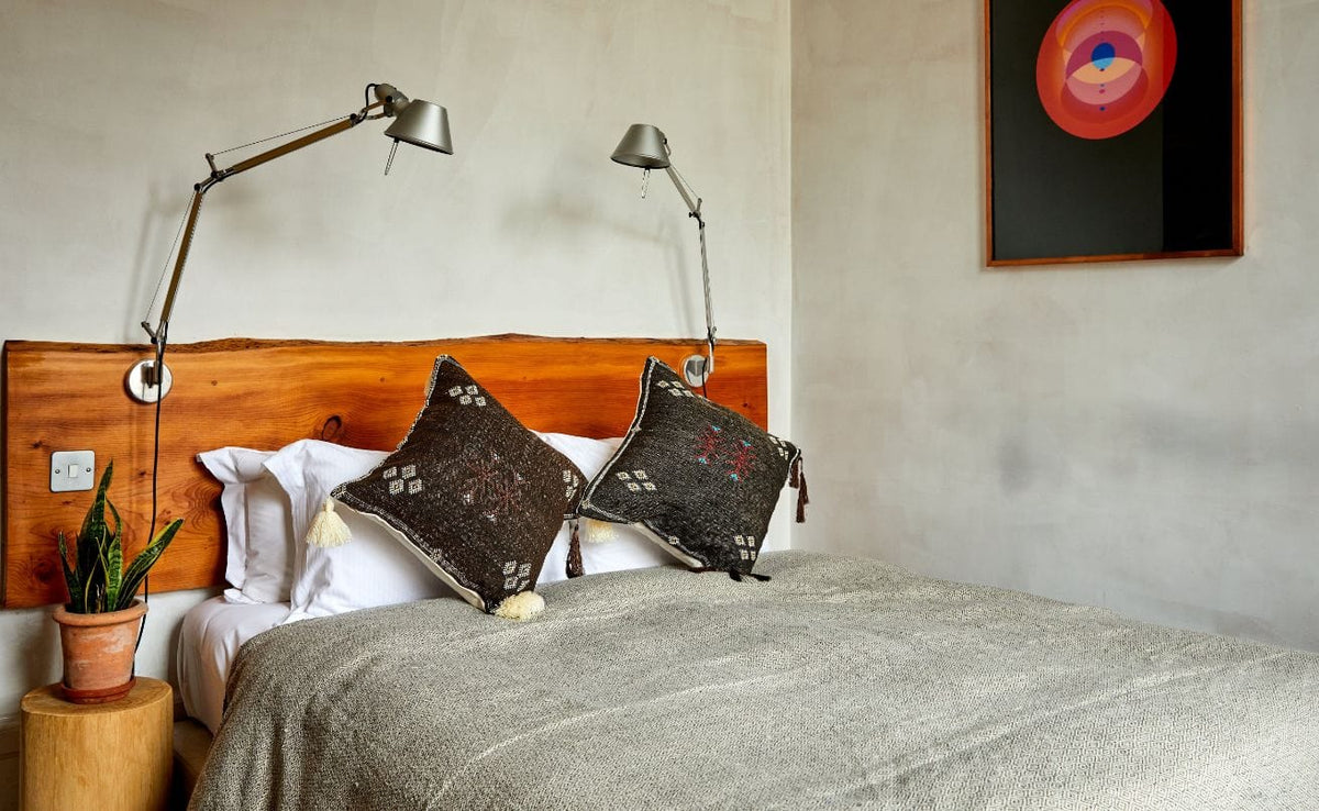 two Sabra cactus silk pillows on a bed