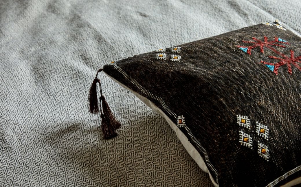 side view of cactus silk pillow on a bed